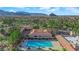 Aerial view of a community featuring a pool, clubhouse, palm trees, and mountains in the background at 9013 Litchfield Ave, Las Vegas, NV 89134