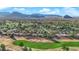 Aerial view of a golf course community with mountain views, lush green fairways, and tree-lined streets at 9013 Litchfield Ave, Las Vegas, NV 89134