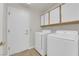 Laundry room with washer, dryer, tile flooring, and bright white cabinets at 9013 Litchfield Ave, Las Vegas, NV 89134