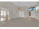 Bright living room featuring neutral walls, carpet, chandelier, and view to front door at 9013 Litchfield Ave, Las Vegas, NV 89134