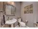 Half bathroom with a pedestal sink, standard toilet, and decorative wall tiles at 940 Riverlawn Pl, Las Vegas, NV 89138