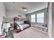 Cozy bedroom featuring a wooden bunk bed and a storage bench beneath two bright windows at 940 Riverlawn Pl, Las Vegas, NV 89138