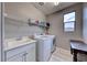 Neat laundry room with a washing machine, dryer, sink, and storage shelf at 940 Riverlawn Pl, Las Vegas, NV 89138