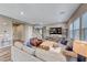 Comfortable living room featuring a plush sofa, stylish decor, and a staircase in a naturally lit space at 940 Riverlawn Pl, Las Vegas, NV 89138