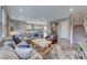 Spacious living room with hardwood floors, a large sofa, and an open view to the kitchen and staircase at 940 Riverlawn Pl, Las Vegas, NV 89138