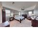 Comfortable main bedroom featuring a ceiling fan, multiple windows, and ample furniture space for a relaxing retreat at 940 Riverlawn Pl, Las Vegas, NV 89138