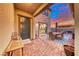 Cozy patio featuring brick flooring, string lights, and outdoor dining furniture at 940 Riverlawn Pl, Las Vegas, NV 89138