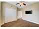 A bright bedroom is equipped with a ceiling fan, hardwood floors, closet and flatscreen television at 10247 Gladstone Peak St, Las Vegas, NV 89166