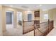 Hallway with wooden banister leading to bathroom, bedroom, and built-in cabinets at 10247 Gladstone Peak St, Las Vegas, NV 89166