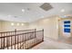 Upstairs hallway featuring a wooden banister and a view into a room with a striped accent wall at 10247 Gladstone Peak St, Las Vegas, NV 89166