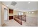 Upstairs landing with carpet, wooden railing, and dark cabinets at 10247 Gladstone Peak St, Las Vegas, NV 89166