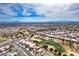 Wide aerial shot displaying a community near a golf course and mountain range on a sunny day at 10421 Shoalhaven Dr, Las Vegas, NV 89134