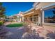 A covered patio extends from this home, with a view of a manicured backyard and golf course at 10421 Shoalhaven Dr, Las Vegas, NV 89134