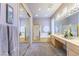 Elegant bathroom with double sinks, large mirrors, and a luxurious soaking tub, creating a spa-like experience at 10421 Shoalhaven Dr, Las Vegas, NV 89134