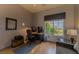 Cozy bedroom with a dedicated workspace, comfortable chair, and bright natural light at 10421 Shoalhaven Dr, Las Vegas, NV 89134