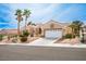 Charming single-story home with a well-manicured lawn, mature palm trees, and a two-car garage at 10421 Shoalhaven Dr, Las Vegas, NV 89134
