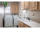 Functional laundry room with a washer, dryer, sink, and cabinets for ample storage at 10421 Shoalhaven Dr, Las Vegas, NV 89134