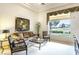 Bright living room with plush carpet, comfortable seating, and a large window overlooking the yard at 10421 Shoalhaven Dr, Las Vegas, NV 89134