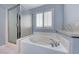 Bright bathroom showcasing a garden tub, separate glass-enclosed shower and shuttered window at 10924 Bandol Pl, Las Vegas, NV 89141