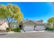 Charming home featuring a two-car garage, lush landscaping, and a well-maintained lawn at 10924 Bandol Pl, Las Vegas, NV 89141