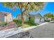 Inviting home exterior featuring a well-manicured lawn, mature tree, and a two-car garage at 10924 Bandol Pl, Las Vegas, NV 89141