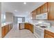 Traditional kitchen featuring oak cabinetry, white appliances, tile flooring, and ample counter space at 10924 Bandol Pl, Las Vegas, NV 89141