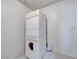 Stacked washer and dryer unit in a laundry room, featuring tile flooring and great functionality at 10924 Bandol Pl, Las Vegas, NV 89141
