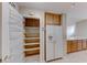 Kitchen pantry featuring built-in shelving, providing generous storage space, and a full-sized refrigerator at 10924 Bandol Pl, Las Vegas, NV 89141