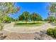 Circular walkway leads to a grassy park area with shade trees and manicured landscaping at 10924 Bandol Pl, Las Vegas, NV 89141