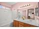 Bright bathroom features double sink vanity, arched mirror, and tub shower with white tile surround at 1184 Warm Canyon Way, Las Vegas, NV 89123