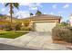 Inviting one-story home featuring a spacious driveway, desert landscaping, and an attached two-car garage at 1184 Warm Canyon Way, Las Vegas, NV 89123