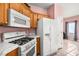 Kitchen featuring oak cabinets, white appliances, and tile floors at 1184 Warm Canyon Way, Las Vegas, NV 89123
