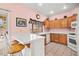 Kitchen features oak cabinets, tile countertops, a white tile backsplash, and a breakfast bar at 1184 Warm Canyon Way, Las Vegas, NV 89123