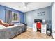 A cozy bedroom features hard surface flooring, a ceiling fan and a gaming desk at 1422 Ozzie Smith Ave, Henderson, NV 89074