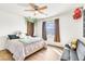 Inviting bedroom with wood floors, a ceiling fan, and a cozy bed and couch at 1422 Ozzie Smith Ave, Henderson, NV 89074
