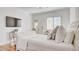 Bright primary bedroom with a TV, white furniture, hardwood floors, and natural light at 15 Via Mantova # 104, Henderson, NV 89011