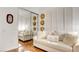 This bedroom features a cream colored sofa, mirrored closet doors, and decorative hats hung on the wall at 15 Via Mantova # 104, Henderson, NV 89011