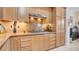 Bright kitchen featuring tile backsplash, modern appliances, and wooden cabinetry at 15 Via Mantova # 104, Henderson, NV 89011