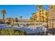 Community pool and lounge area surrounded by lush landscaping with palm trees and mountain views at 15 Via Mantova # 104, Henderson, NV 89011