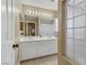 Well-lit bathroom with double sinks, vanity, mirrors, a walk-in shower, and a textured glass block window at 1730 Juniper Twig Ave, Las Vegas, NV 89183