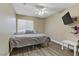 Comfortable bedroom with a queen-sized bed, wood-look flooring, and natural light from a window at 1730 Juniper Twig Ave, Las Vegas, NV 89183