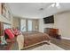 A spacious main bedroom featuring hardwood floors, a plush area rug, and large windows at 1730 Juniper Twig Ave, Las Vegas, NV 89183
