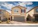 Charming two-story home featuring a welcoming facade, gray garage, and desert landscaping for a modern appeal at 1819 Wild Grain Ave, North Las Vegas, NV 89086