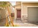 Close-up of a home's front entrance, featuring a red front door, a gray garage, and stone accents at 1819 Wild Grain Ave, North Las Vegas, NV 89086