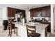 Kitchen with granite island, stainless steel appliances and dark cabinets. Bar stool seating included at 1819 Wild Grain Ave, North Las Vegas, NV 89086