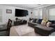 Cozy living room featuring neutral carpet, large television, and lots of light from large windows at 1819 Wild Grain Ave, North Las Vegas, NV 89086