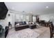 Comfortable living room includes a sectional couch, large television and carpet flooring at 1819 Wild Grain Ave, North Las Vegas, NV 89086