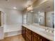 Bathroom featuring a double vanity, a soaking tub, and a walk-in shower enclosed in glass at 1973 Ardilea St, Las Vegas, NV 89135