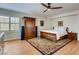 Cozy bedroom featuring wood floors, a ceiling fan, and plantation shutters for natural light and privacy at 1973 Ardilea St, Las Vegas, NV 89135