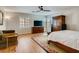 Bright bedroom with a ceiling fan, wood floors, plantation shutters, and a comfortable seating area at 1973 Ardilea St, Las Vegas, NV 89135